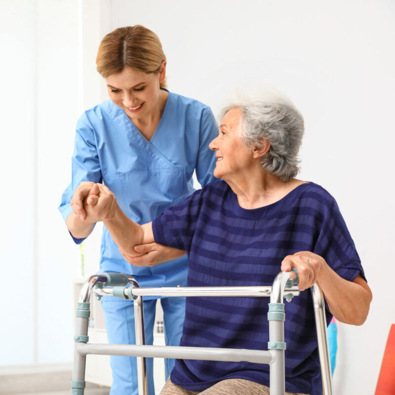 woman helping senior walk